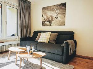 una sala de estar con sofá y una foto de una cabra en Sankt Moritz Spirit Piz Bernina 5, en St. Moritz