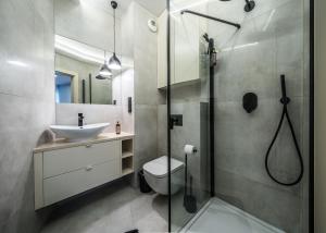 a bathroom with a shower and a toilet and a sink at Rent like home - Krysiewicza 3 in Poznań
