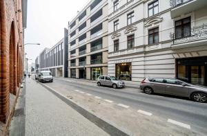 two cars parked on a street in front of buildings at Rent like home - Krysiewicza 3 in Poznań
