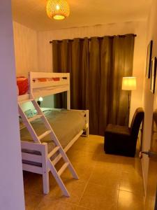 a bedroom with a bunk bed and a chair at Casa Rafol in Monte Pego