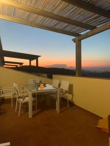 una mesa blanca y sillas en un balcón con vistas a la puesta de sol en Casa Rafol, en Monte Pego