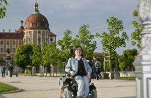 a young child is riding a toy vehicle in front of a building at Z Testhotel Zur Sonne in Dresden