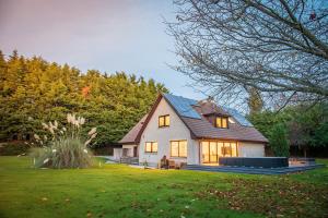 a small white house with a gambrel roof at FAMILY FRIENDLY, HOT TUB, Fire Pit, Spacious & Modern in Fochabers