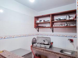 a kitchen with a stove and a sink at Apartamentos EL BARCO in Sidi Ifni
