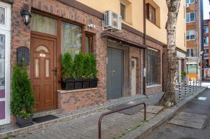 un edificio de ladrillo con una puerta marrón en una calle en *The Music House* Exclusive Studio in the Heart of Sofia en Sofía