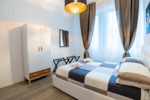 een slaapkamer met een bed, een kast en een raam bij Nord Milano Luxury Apartments in Bresso