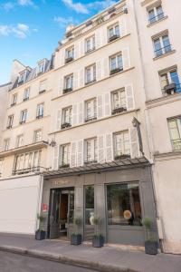 a large white building with potted plants in front of it at Hotel Le Placide Saint-Germain Des Prés in Paris