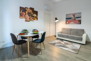 een woonkamer met een tafel en stoelen en een bank bij Nord Milano Luxury Apartments in Bresso