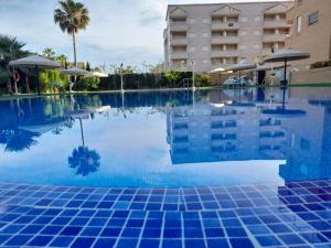 einem Pool mit blauen Fliesen vor einem Gebäude in der Unterkunft ACV Segunda Linea in Oropesa del Mar