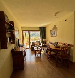 ein Wohnzimmer mit einem Tisch und ein Wohnzimmer mit einem Sofa in der Unterkunft Apartamentos SNÖ Cerler in Aramón Cerler