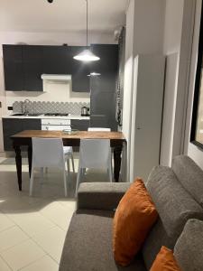 a living room with a couch and a table and a kitchen at CUTE AND COZY CENTRO CITTA' in Bergamo