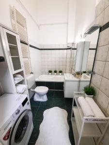 a bathroom with a washer and a toilet and a sink at OASIS Guest House Budapest in Budapest