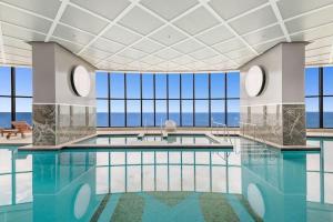 a large swimming pool with a view of the ocean at Sea view Beachfront apartment in surfers in Gold Coast
