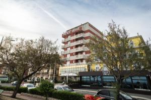 a hotel building with cars parked in a parking lot at Hotel Palace in Catanzaro Lido