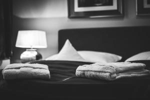 two towels are sitting on a bed with a lamp at Hotel Wagner im Dammtorpalais in Hamburg