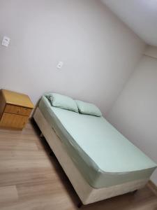 sypialnia z łóżkiem i szafką nocną w obiekcie Residencial Jardim Curitiba w mieście Kurytyba
