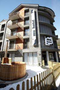 un edificio con una valla de madera delante de él en Hotel MU & SPA, en La Cortinada