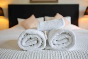 - 2 serviettes laminées au-dessus d'un lit dans l'établissement Central Hobart - Beautiful Apartment, à Hobart