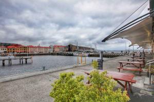 - une vue sur un port de plaisance avec bancs et bâtiments dans l'établissement Central Hobart - Beautiful Apartment, à Hobart