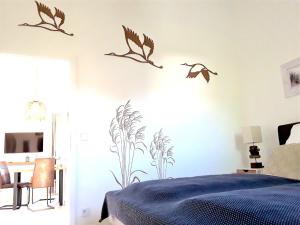 a bedroom with a bed with birds on the wall at Nordlicht in Zingst