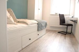 a bedroom with a bed with a desk and a chair at Nordlicht in Zingst
