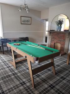 una mesa de billar en una sala de estar con accesorios en Newton House en Alstonfield