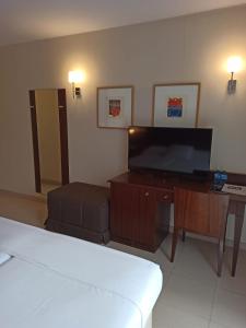 uma sala de estar com uma televisão de ecrã plano e um sofá em Hotel MU & SPA em La Cortinada