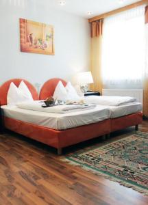 a bedroom with a large bed with a large window at Stadthotel Restaurant Auerhahn in Vöcklabruck