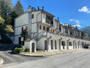 un grand bâtiment blanc sur le côté d'une route dans l'établissement La casina di Francy, à Castelsantangelo sul Nera