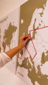 una persona está apuntando a un mapa en una pared en Pollicino House, en Caltagirone