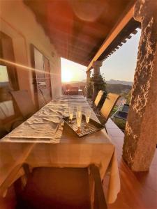 einen Holztisch mit Weingläsern auf dem Balkon in der Unterkunft Donnigheddu in Rudalza