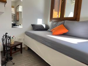 a bed with an orange pillow on it in a room at La casina di Francy in Castelsantangelo sul Nera