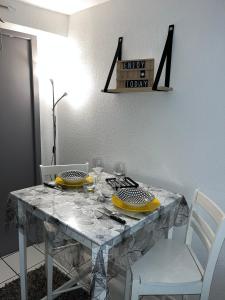 a dining room table with two chairs and a table with yellow plates at Studio Porte du Croux in Nevers