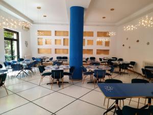 una stanza con tavoli e sedie e una grande colonna blu di Hotel Le Grazie a Portovenere