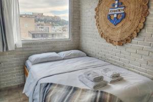 - un lit avec serviettes dans une chambre avec fenêtre dans l'établissement Wake up with Acropolis view!, à Athènes