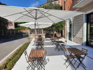 a group of tables and chairs under an umbrella at Hotel Le Grazie in Portovenere