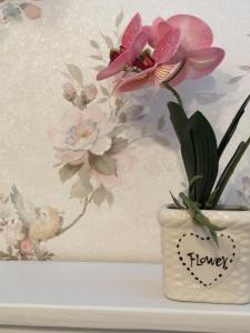 Un jarrón con flores junto a un pájaro en EneaHouse, en Fiumicino