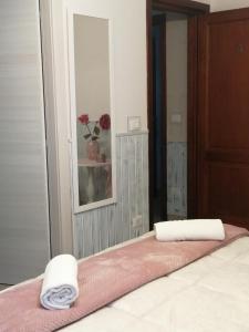 a bedroom with a bed with two towels on it at EneaHouse in Fiumicino