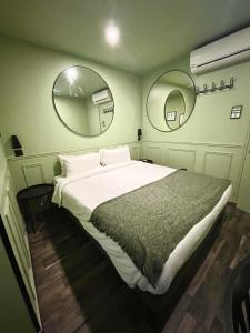 a bedroom with a large bed and two mirrors at Hotel de Berne in Nice