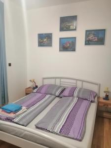 a bed with purple sheets and pillows in a bedroom at Ubytování Eva in Luhačovice