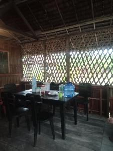 a table and chairs in a room with windows at Marine homestay in Fam