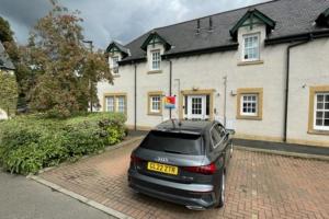 um carro estacionado em frente a uma casa em Peebles Cardona Cozy 2 x bedroom Apartment em Cardrona Mains