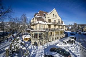 a large house with cars parked in the snow at Willa Excelsior in Zakopane