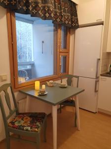 a table and chairs in a kitchen with a window at Apartment Marja's place in Rovaniemi