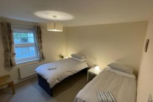 a bedroom with two beds and a window at Peebles Cardona Cozy 2 x bedroom Apartment in Cardrona Mains