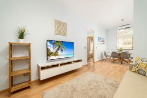 a living room with a flat screen tv on a white wall at -MalagaSunApts- Stylish City Centre Pool&Parking in Málaga