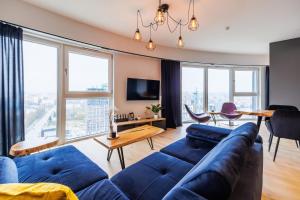ein Wohnzimmer mit einem blauen Sofa und einem Tisch in der Unterkunft Panorama Capital Black in Rzeszów