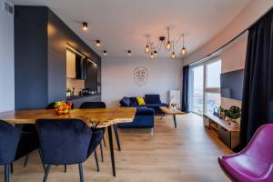 ein Esszimmer und ein Wohnzimmer mit Tisch und Stühlen in der Unterkunft Panorama Capital Black in Rzeszów