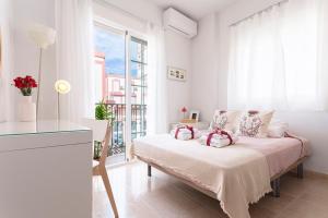 biały pokój z łóżkiem i oknem w obiekcie -MalagaSunApts- Bright City Centre Studio w Maladze