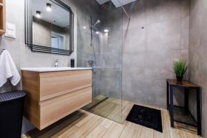 ein Badezimmer mit Waschbecken und Dusche in der Unterkunft Panorama Capital Black in Rzeszów + 14 Fotos